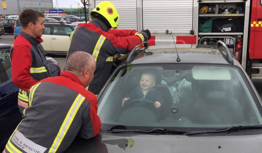 Bombeiros tentam libertar bebê do carro e o pequeno se diverte com a situação