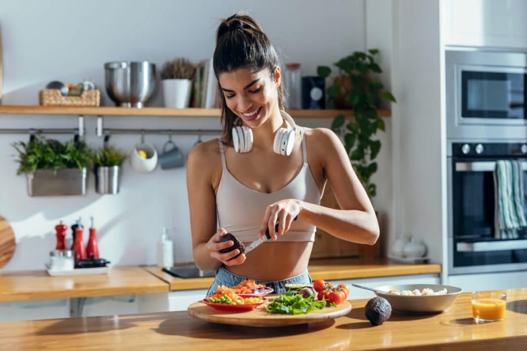Fintess woman making a healthy poke bowl in the kitchen at home. Dieta anti-inchaço viraliza entre mulheres: veja os alimentos queridinhos que estão fazendo sucesso